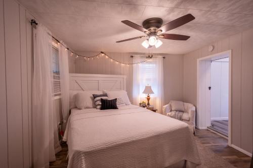 a bedroom with a white bed and a ceiling fan at Farmhouse of Blessings in Dundee