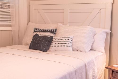 a white bed with four pillows on it at Farmhouse of Blessings in Dundee