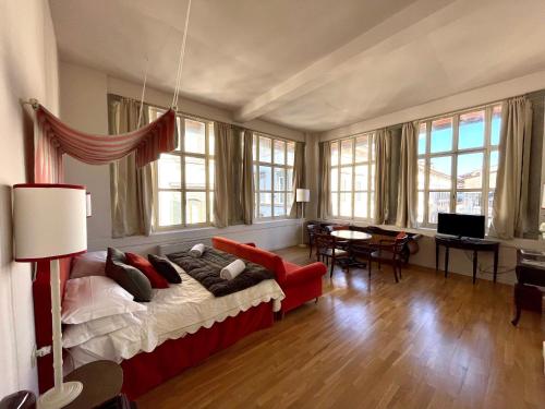 Residenza dei Pucci في فلورنسا: غرفة معيشة مع أريكة حمراء وطاولة