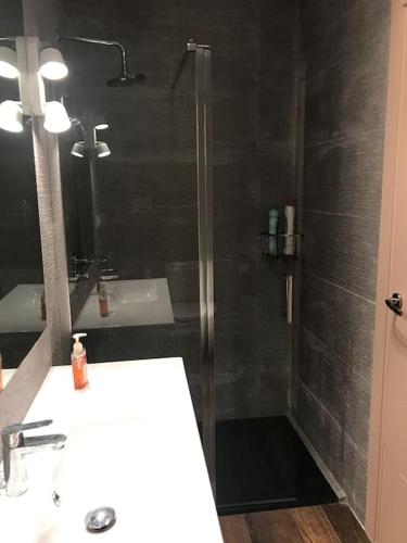 a bathroom with a shower with a sink and a mirror at Casa Mirador de Entrepeñas in Guadalajara