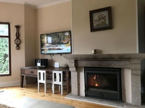 a living room with a fireplace and a television at Villa Entrepeñas in Guadalajara