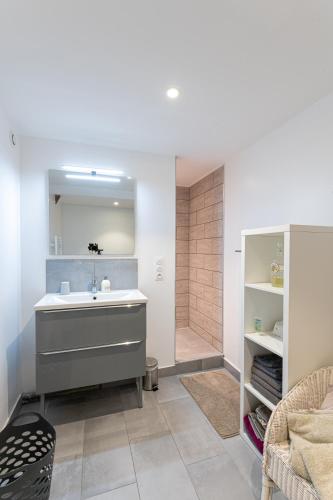 une salle de bain avec un lavabo et une douche dans l'établissement Le Manoir des Bréholles, à Goustranville