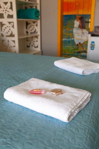 two white towels sitting on top of a bed at Pousada Guaricana in Pontal do Paraná