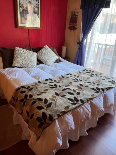 uma cama com um cobertor castanho e branco em Cabaña Ruca Quimey em Villarrica