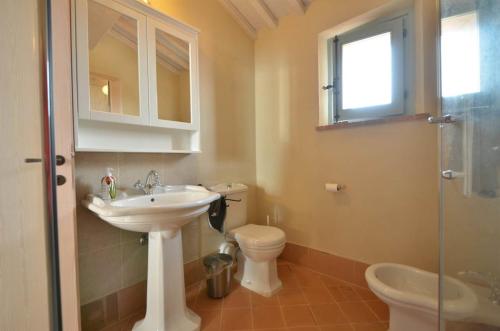 a bathroom with a sink and a toilet and a glass shower at Appartamento Quercia in Trequanda