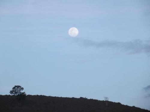 a moon in the sky over a hill at Rancho do Colega in Santa Branca