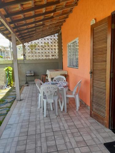 a patio with a table and chairs on a porch at Casa em Cabo Frio in Cabo Frio