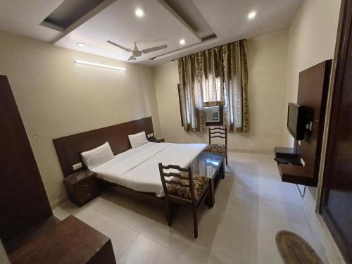 una camera da letto con un letto e una televisione di Hotel Raghav Palace 1 km Jaipur Junction & Bus Stand Sindhi Camp a Jaipur