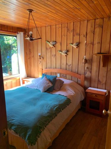 a bedroom with a bed with fish on the wall at Cabaña Pucón in Pucón