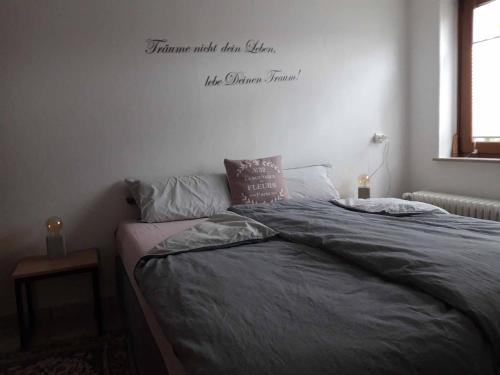 um quarto com uma cama com palavras na parede em Ferienwohnung am Ginkgo Baum em Bad Pyrmont