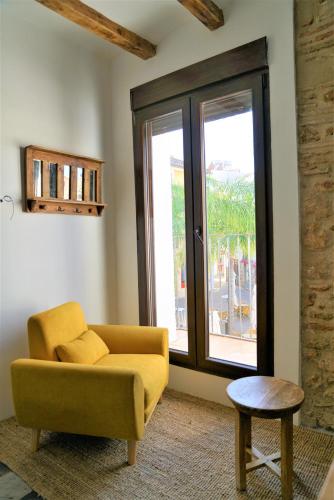 a living room with a yellow couch and a window at Romantico Apartamento en el Puerto de Denia in Denia