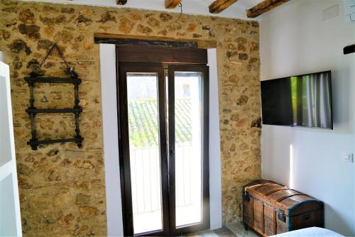 een kamer met een stenen muur met een deur en een raam bij Romantico Apartamento en el Puerto de Denia in Denia