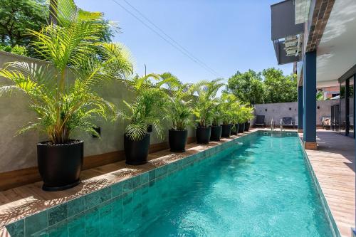 uma piscina com vasos de plantas ao lado de um edifício em Duplex com churrasqueira a 200m da praia #JA21 em Florianópolis