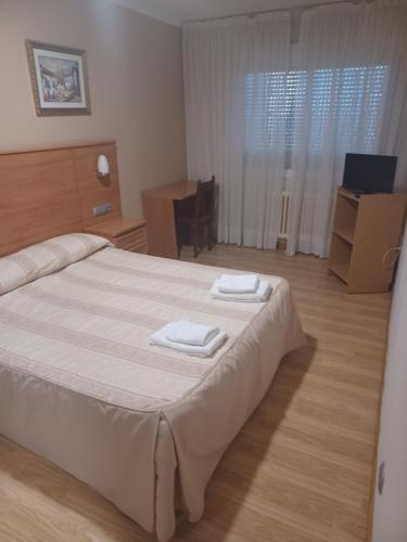 sypialnia z łóżkiem i dwoma ręcznikami na nim w obiekcie Hotel 2 de mayo 2 w mieście Xinzo de Limia