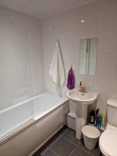 a bathroom with a tub and a sink and a toilet at Converted Mill Apartment in Manchester