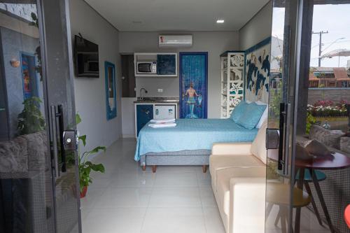 a room with a bed and a couch in it at Pousada Guaricana in Pontal do Paraná