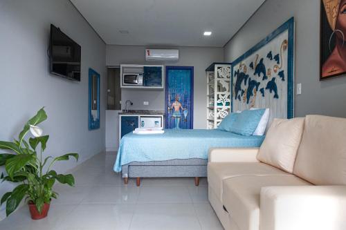 a bedroom with a bed and a couch at Pousada Guaricana in Pontal do Paraná
