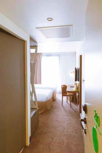 a bedroom with a bunk bed and a desk and a bed at Campanile PRIME - Rungis Orly in Chevilly-Larue