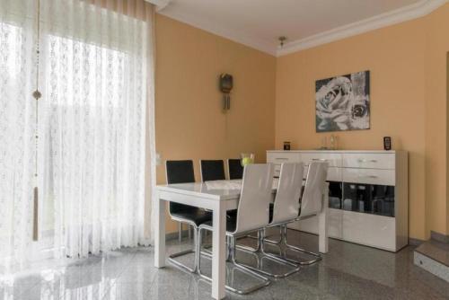 a dining room with a white table and chairs at Private House in Hannover