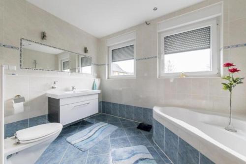 a bathroom with a tub and a toilet and a sink at Private House in Hannover