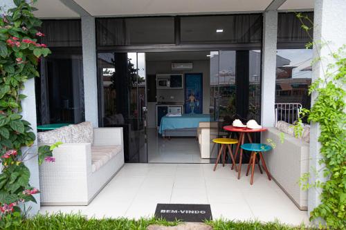 a patio with a table and chairs and a kitchen at Pousada Guaricana in Pontal do Paraná