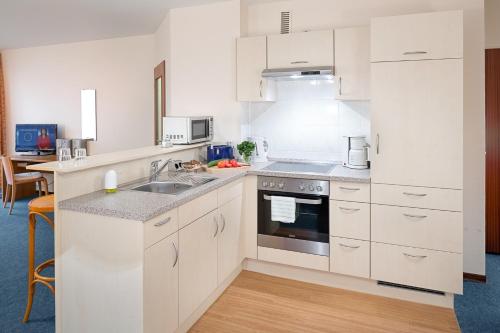 a kitchen with white cabinets and a sink at E 221, Alte Werft 24 in Lübeck