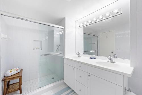 a white bathroom with a sink and a shower at Beachfront condo with pool, tennis and fitness center in Marco Island