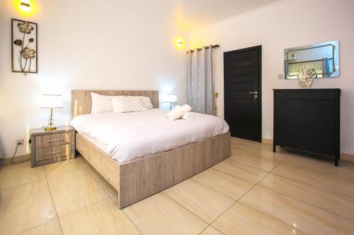 a bedroom with a large bed and a black cabinet at ADA - Granite Court in Accra