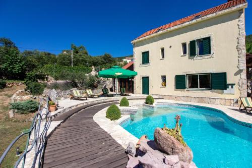 uma casa com piscina ao lado de um edifício em Magnificent Villa Olka With Private Pool and Sauna em Žeževica