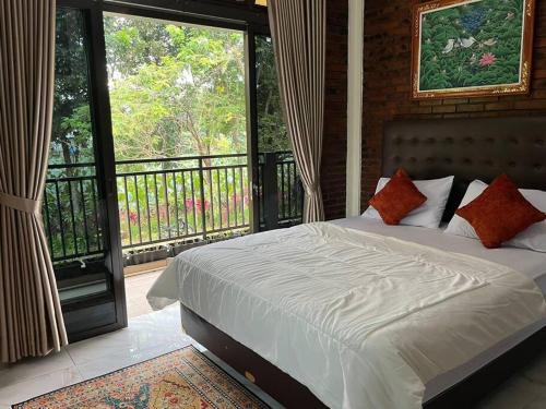 a bedroom with a bed and a balcony with windows at Arunni garden in Bogor