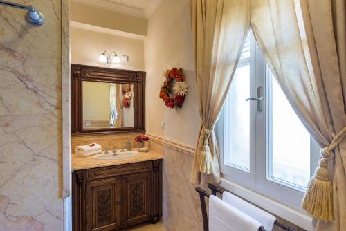 a bathroom with a sink and a mirror and a window at Pantaleon House in Ano Syros