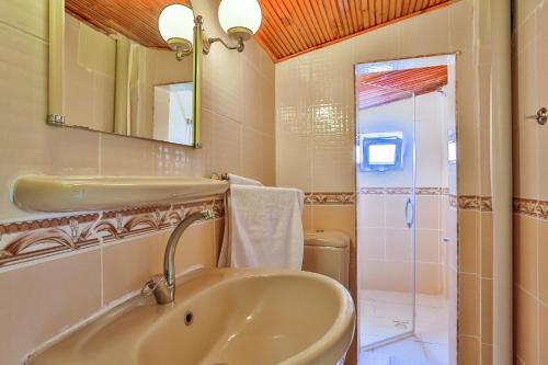 a bathroom with a sink and a mirror and a shower at Club Hotel Gultur in Kucukkuyu