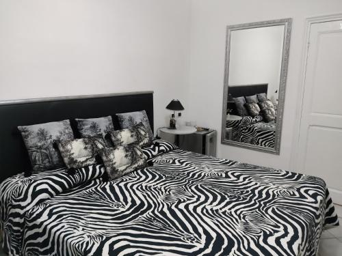 a black and white bed in a bedroom with a mirror at Hotel Sanremo in Sanremo