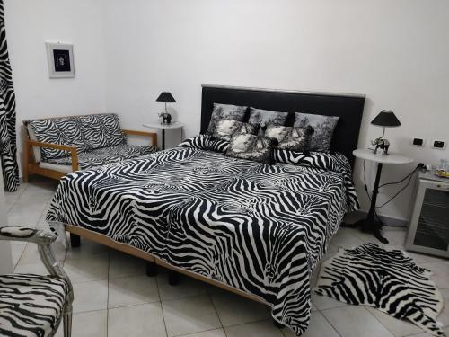 a bedroom with a zebra print bed and a chair at Hotel Sanremo in Sanremo