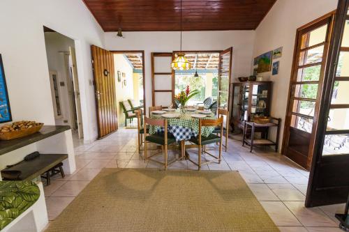 una sala da pranzo con tavolo e sedie di Natureza a 100m da Praia, 4 suítes, amplo jardim a São Sebastião