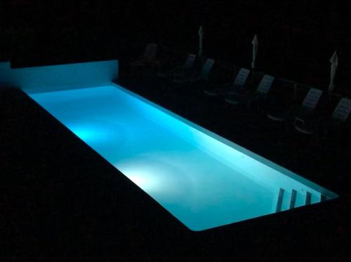 a swimming pool in a dark room with blue lighting at Logis Hôtels Troglododo in Azay-le-Rideau