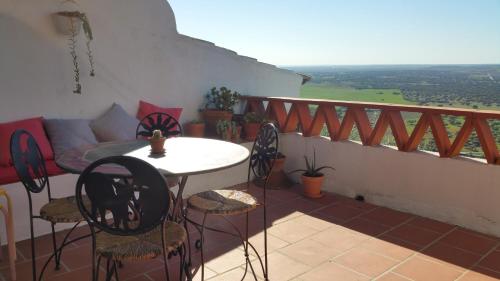 een balkon met een tafel en stoelen en een bank bij Casas Letizia e Sebastião in Monsaraz