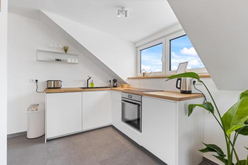 eine Küche mit weißen Schränken und einem Fenster in der Unterkunft Casa Verde: Küche, TV, Nespresso, im Grünen in Starnberg