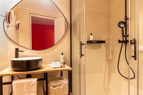 a bathroom with a shower and a sink and a mirror at Aiden by Best Western at Paris Roissy CDG in Roissy-en-France