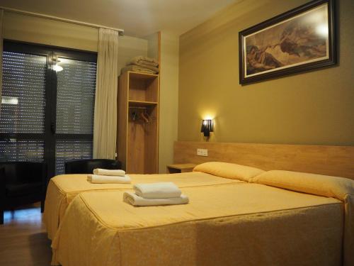 a bedroom with two beds with towels on them at Hostal Acella in Pamplona