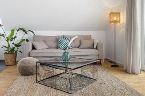 ein Wohnzimmer mit einem Sofa und einem Couchtisch aus Glas in der Unterkunft Casa Verde: Küche, TV, Nespresso, im Grünen in Starnberg