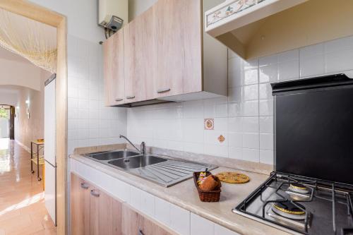 a kitchen with a sink and a stove at Villetta Lido Canne in Torre Lapillo