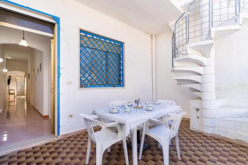 a white table and chairs in a room with a staircase at Villetta Lido Canne in Torre Lapillo