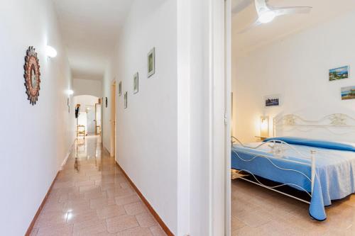 a bedroom with a blue bed and a hallway at Villetta Lido Canne in Torre Lapillo