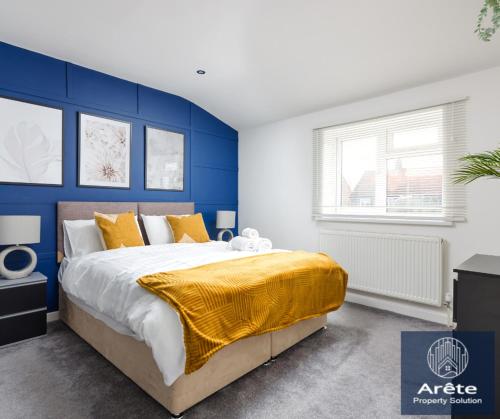 a bedroom with blue walls and a bed with a yellow blanket at Arete Serviced Accommodation - 3 Bedrooms, 4 Beds, with Parking in Merstham