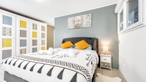 um quarto com uma cama grande e almofadas amarelas em HOMEY ETHAN - Free Parking - Terrasse privée - Wifi et Netflix - Jacuzzi em Monnetier-Mornex