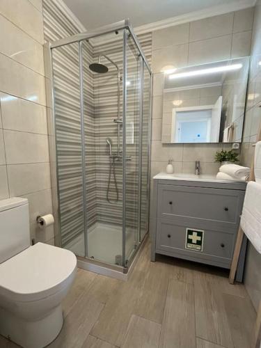a bathroom with a shower and a toilet and a sink at Casa da Ana - Country Home in Terrugem