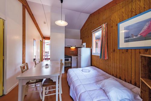 Zimmer mit einem Bett und einem Tisch sowie einer Küche in der Unterkunft Résidence les Sentes in Carcans