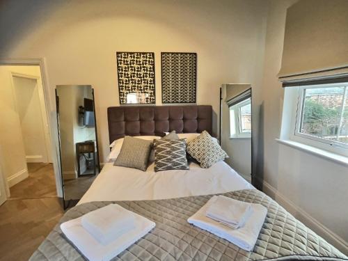 a bedroom with a large bed with two towels on it at The Garden Room YORK in York