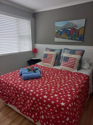 a bedroom with a bed with a red comforter at I Could Live Here - guest house in Sedgefield